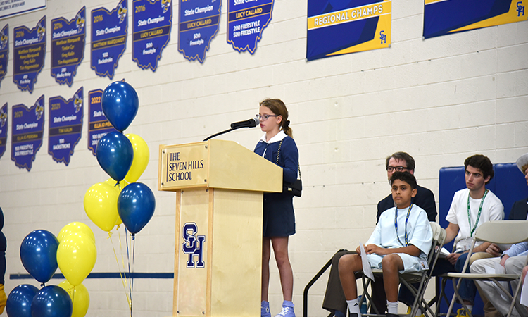 Claire-Morelli-speaks-during-assembly Claire Morelli speaks stands at a podium, delivering her remarks during the all-school assembly