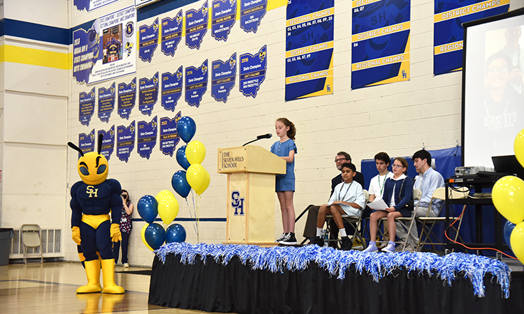Edie-Donovan-speaks-during-assembly Edie Donovan stands on stage, delivering her remarks during the school assembly