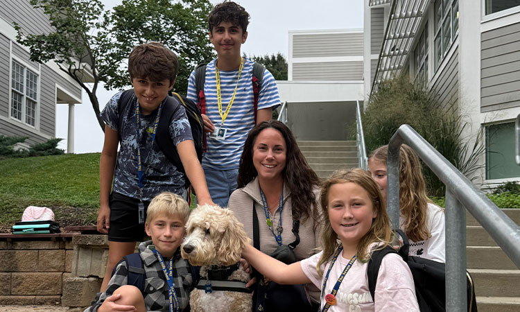Cruz-Joins-Dayna-Sargent-for-Dismissal Cruz, the school therapy dog, sits with students outside the Middle School