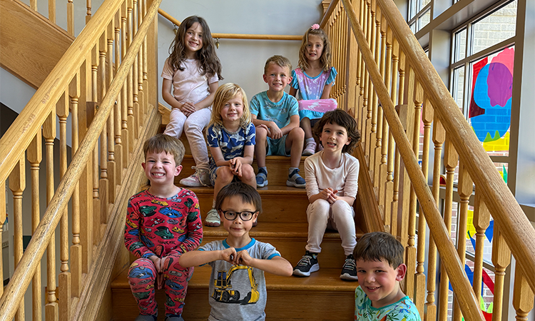 Students sit on the steps in their pajamas