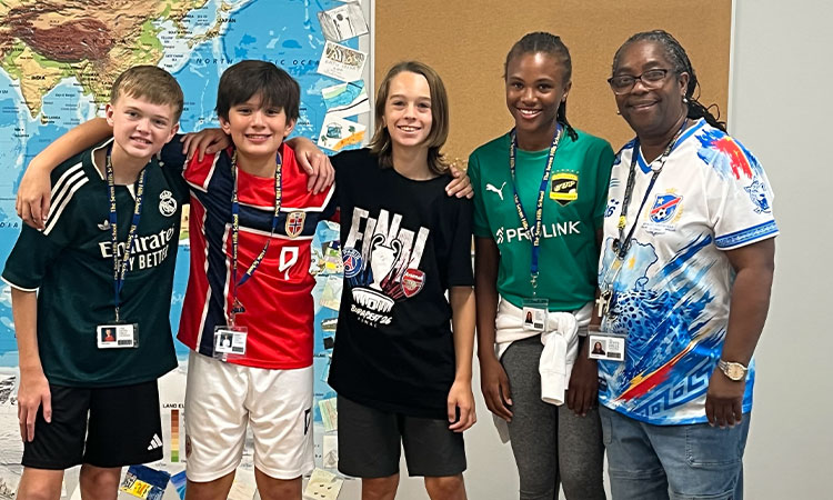 Unofficial-Soccer-Jersey-Day-in-Sixth-Grade-French Students and a teacher pose for a photo in soccer jerseys